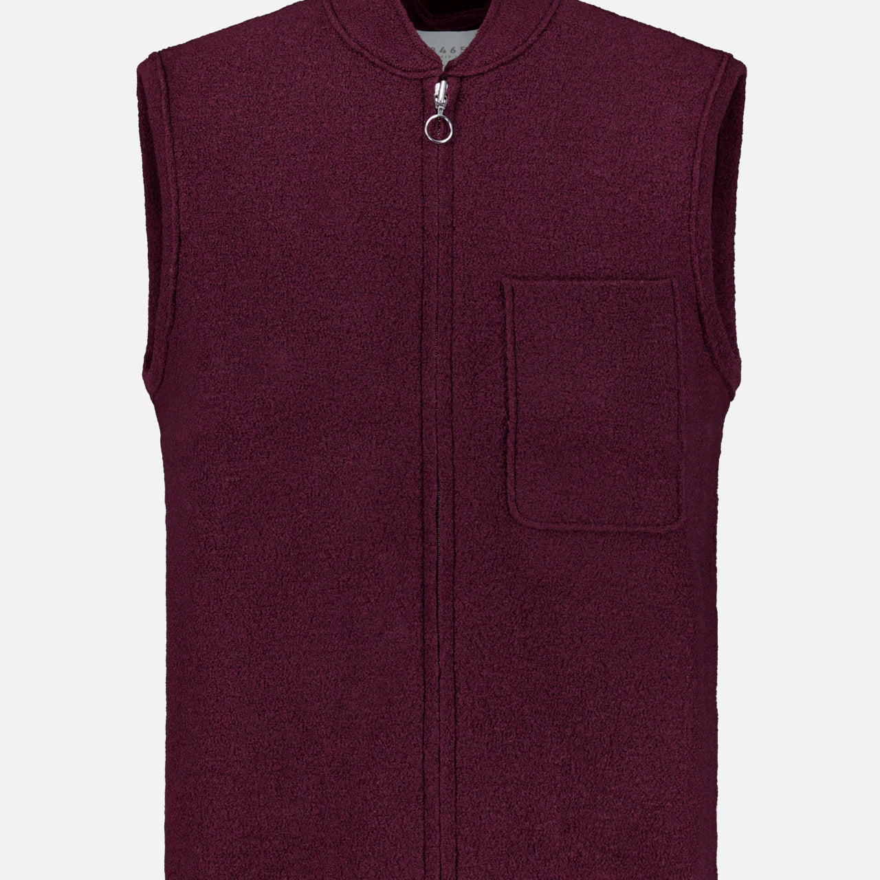 A sleeveless Boiled Virgin Wool Vest by 04651/ A TRIP IN A BAG, in a wine tone, crafted from soft fleece, featuring a front zipper and a single chest pocket, displayed on a plain white background.