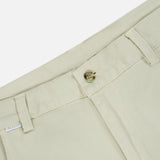 Close-up of the Bull Denim 5-Pocket Pants by 04651/ A TRIP IN A BAG, highlighting the light beige waistband, button, belt loops, small white size tag, and the top of a pocket against a white background.