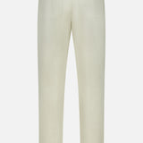 The Bull Denim 5-Pocket Pants by 04651/ A TRIP IN A BAG are shown from the back in beige cotton-blend fabric, featuring two rear pockets, straight legs, and belt loops at the waistband. These versatile neutral pants are displayed against a plain white background.