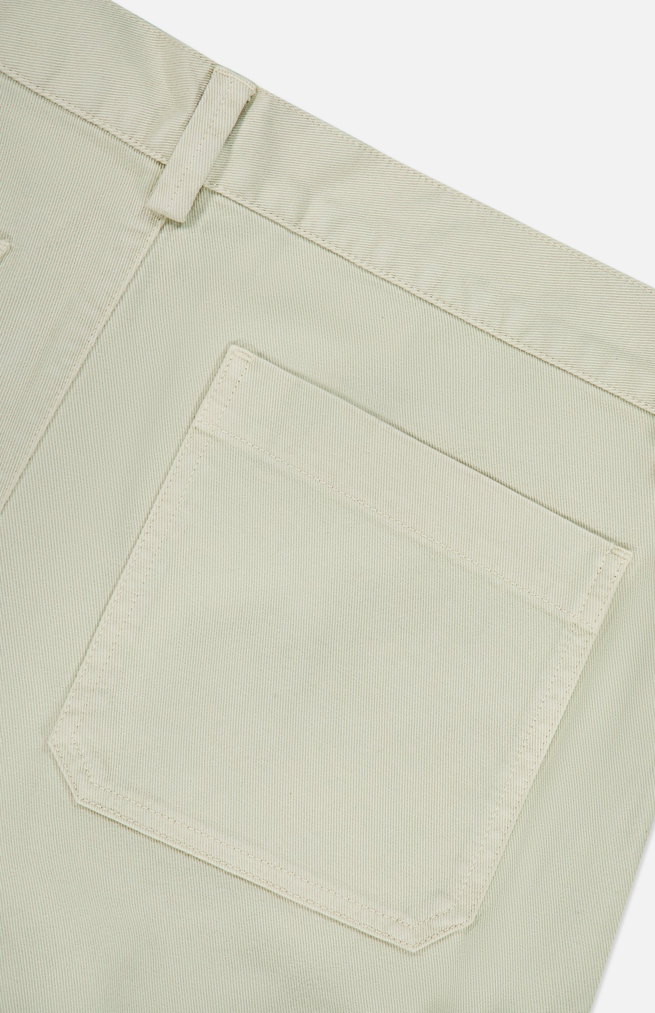 Close-up of the back pocket and waistband of the Bull Denim 5-Pocket Pants by 04651/ A TRIP IN A BAG in light beige cotton-blend fabric, highlighting the texture and stitching details against a white background.