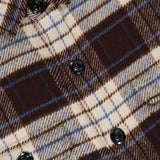 Close-up of a brown, cream, and blue 04651/ A TRIP IN A BAG Checkered Overshirt.