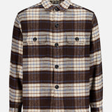 04651/ A TRIP IN A BAG Checkered Overshirt, a long-sleeved button-up travel shirt in a brown, cream, and blue plaid pattern with two buttoned chest pockets.