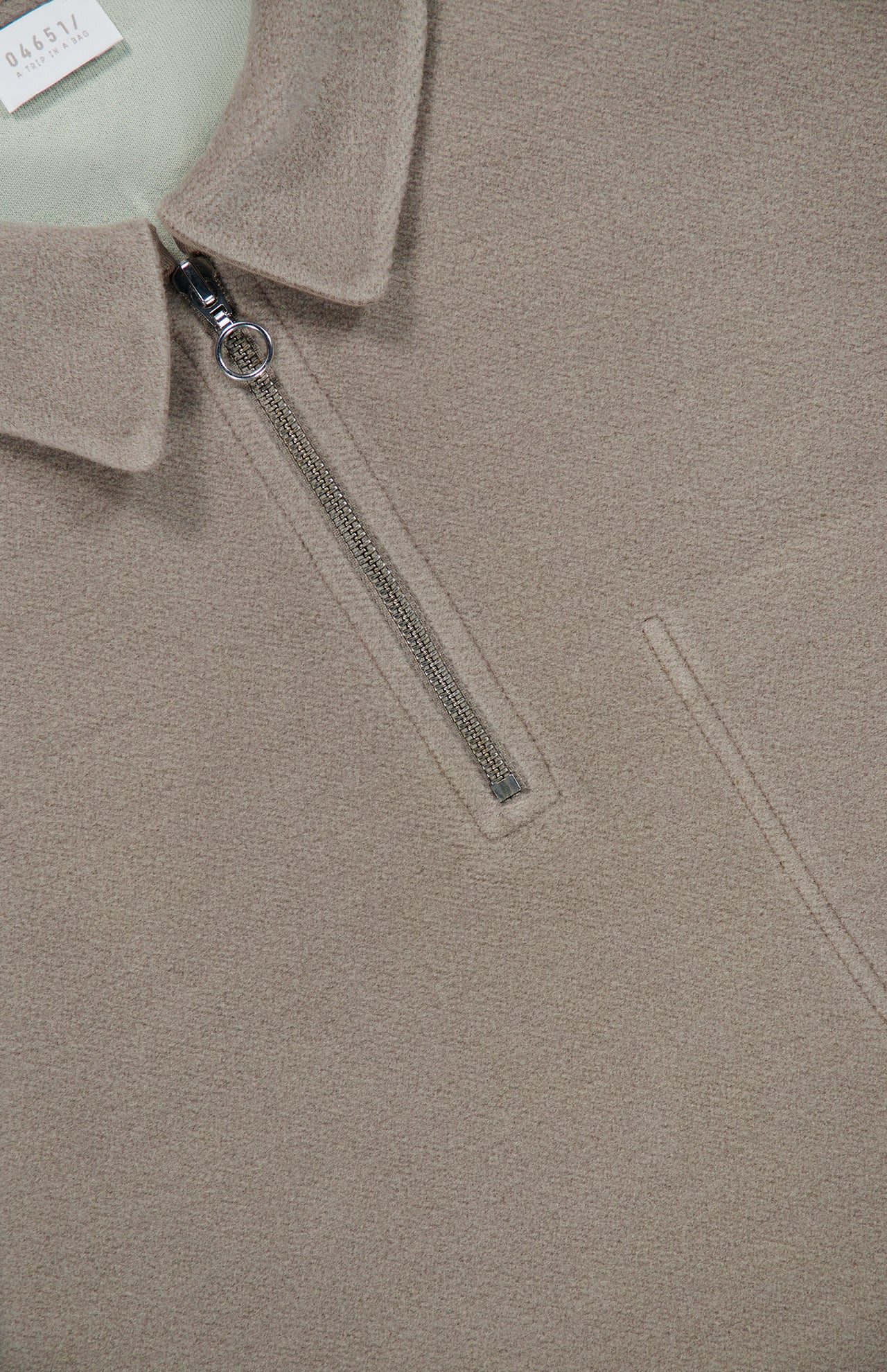 04651/ A TRIP IN A BAG CW Quarter Zip Polo Pullover in a taupe wool-cotton blend, featuring a silver ring-pull zipper and a pale green inner collar.