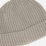 Close-up of a taupe ribbed knit Extreme Cashmere Beanie by 04651/ A TRIP IN A BAG featuring a wide cuff.