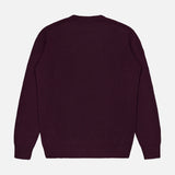 The Extreme Cashmere Crewneck Sweater by 04651/ A TRIP IN A BAG, a plain long-sleeved dark purple cashmere piece with a crew neck, is laid flat with the back facing up against a white background.