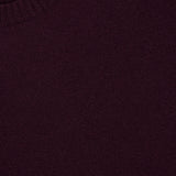 Close-up of the 04651/ A TRIP IN A BAG Extreme Cashmere Crewneck Sweater in dark maroon, featuring a ribbed crew neckline and a small white tag in the top left corner, elegantly highlighting its exquisite “made in Italy” craftsmanship.