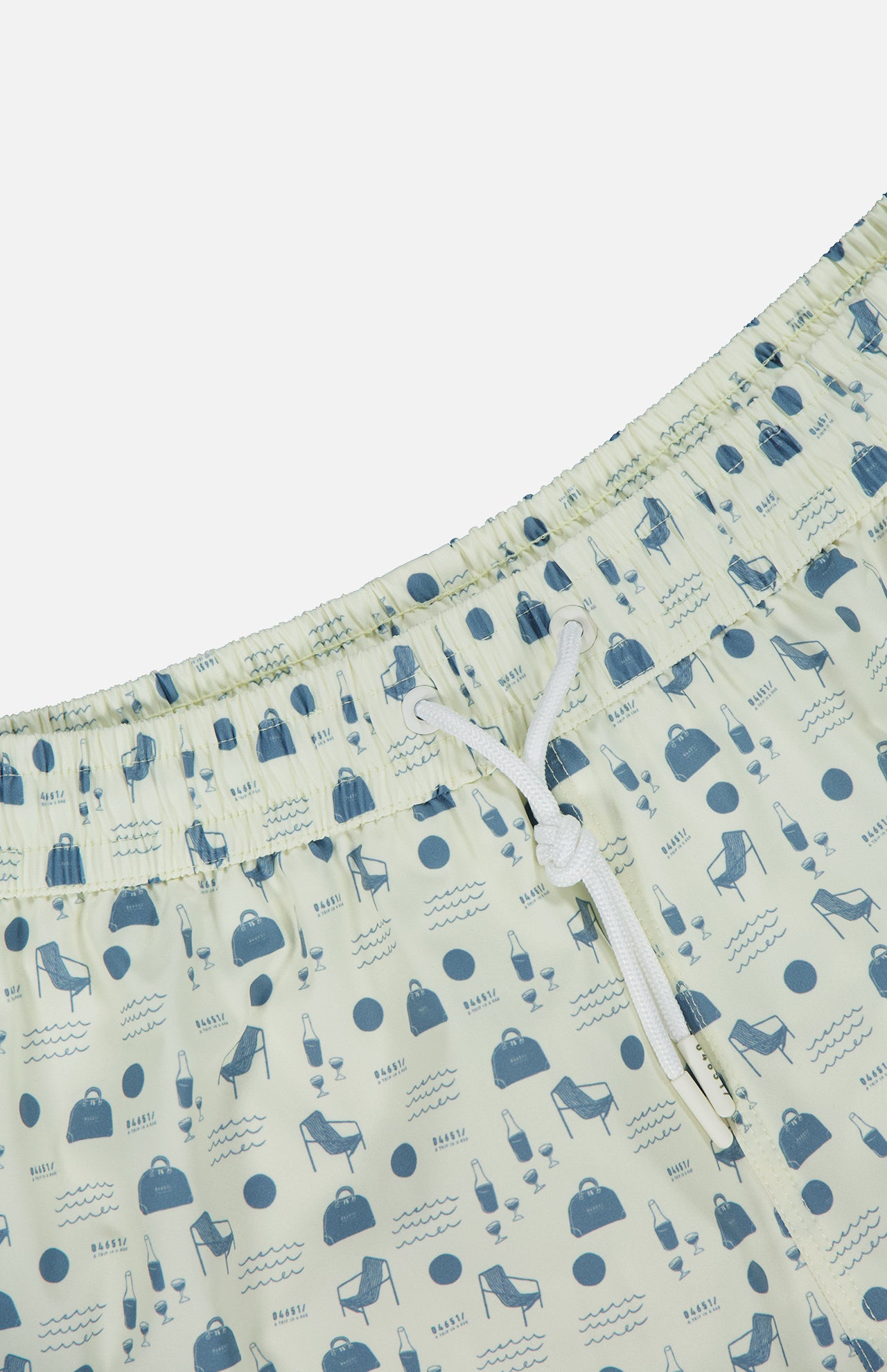 Close-up of Seaside Swim Trunk by 04651/ A TRIP IN A BAG: off-white with an elastic waistband and white drawstrings, featuring a blue beach-themed print—ideal summer beachwear for men.
