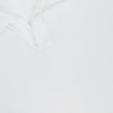 Close-up of the Terry Johnny Long Sleeve Collar Polo Shirt by 04651/ A TRIP IN A BAG, clean and laid flat on a white background, with part of the shirt and neck tag featuring a number and text visible.