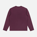 The WJ Long Sleeve T-shirt by 04651/ A TRIP IN A BAG is shown laid flat with the back side visible against a white background. This minimalist, solid dark purple tee is crafted in Portugal for premium quality and comfort.