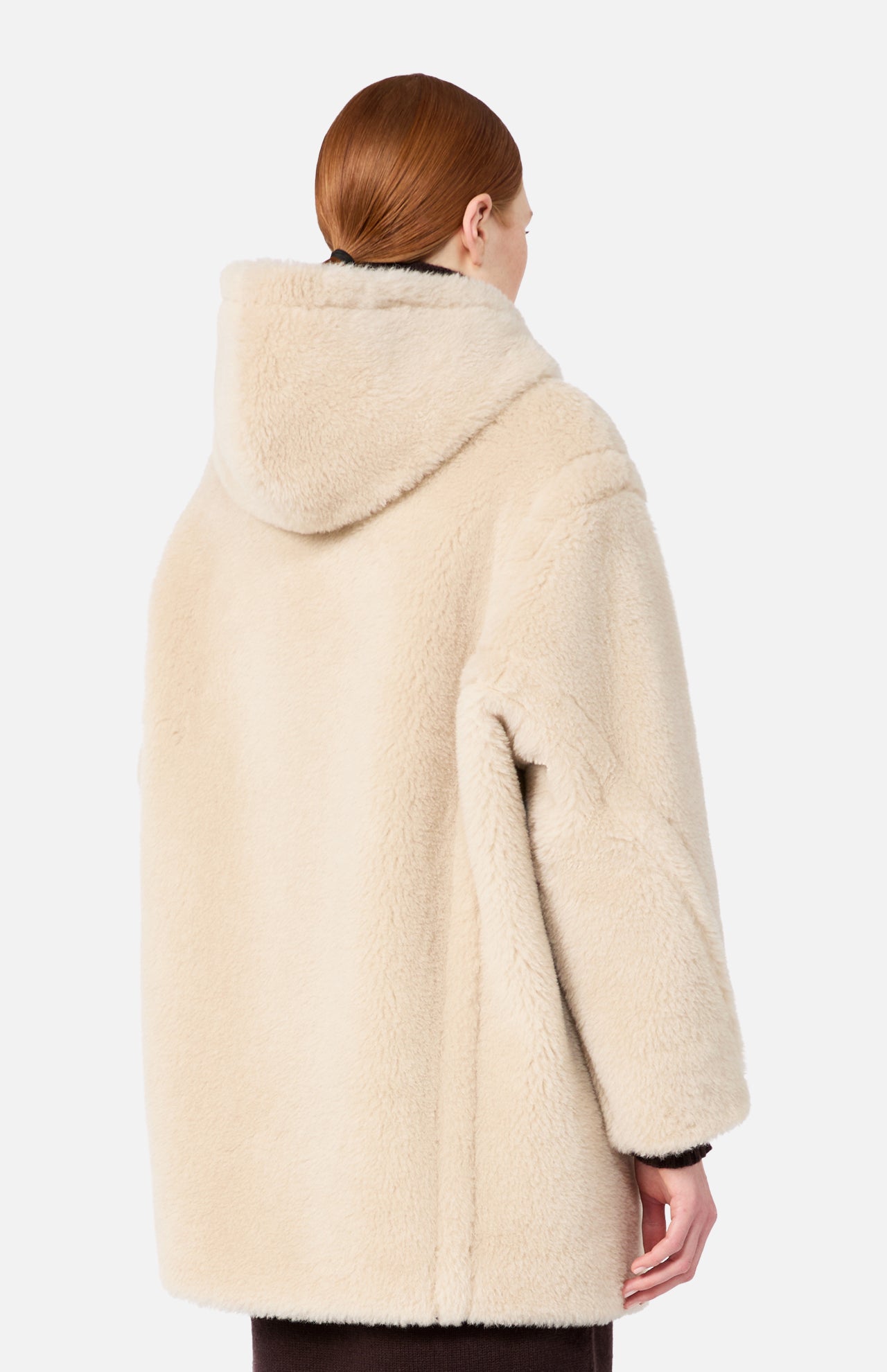 A person viewed from behind, wearing a beige Max Mara Teddy Hooded Coat.