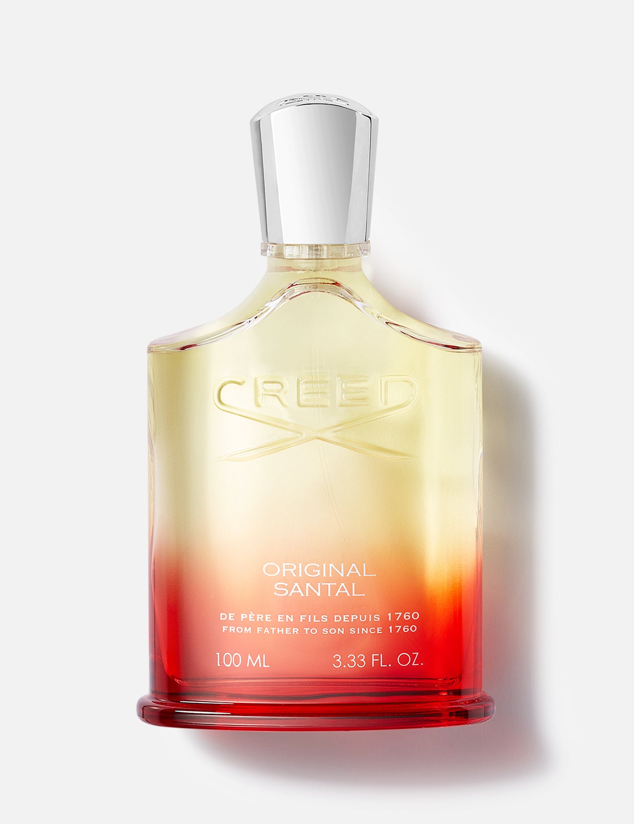 A bottle of CREED Original Santal fragrance, inspired by Mysore sandalwood, features a gradient yellow-to-red design with a silver cap and embossed logo, displayed against a plain white background.