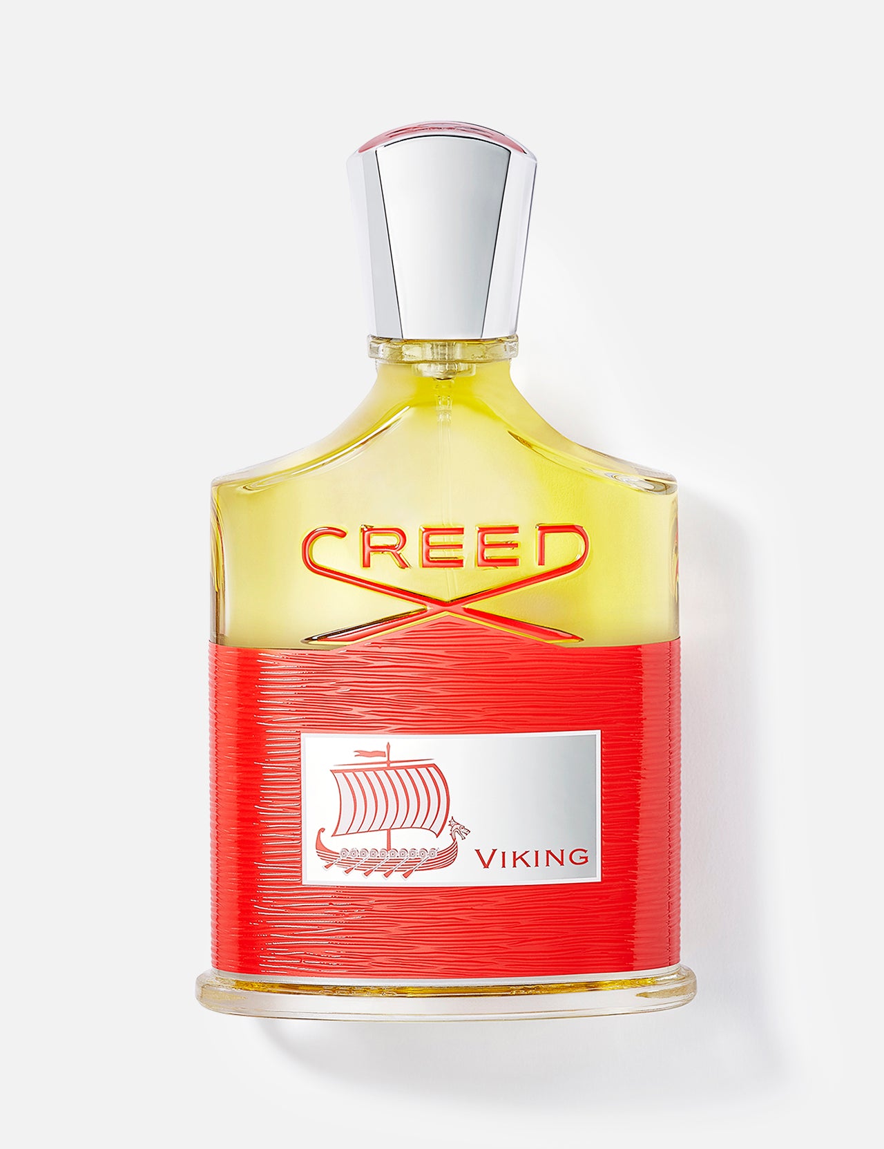 A CREED Viking cologne bottle with a silver cap, yellow liquid, and a red label showing a Viking ship and "Viking"—a bold men's fragrance—displayed on a white background.