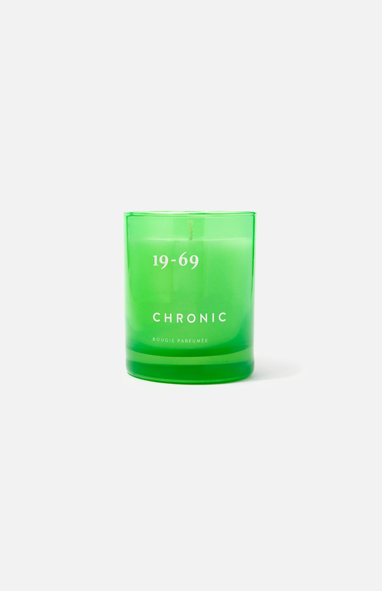 A green glass candle holder labeled 19-69 and Chronic Candle, Bougie Parfumée below, sits on a plain white background. This unique scented candle celebrates the unisex fragrance inspired by the modern lifestyle.