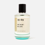 A clear glass bottle of 19-69 Miami Blu EDP 100 ml Fragrance—a unisex scent with fresh aquatic notes—features a black cap and minimalist label, displayed on a white background.