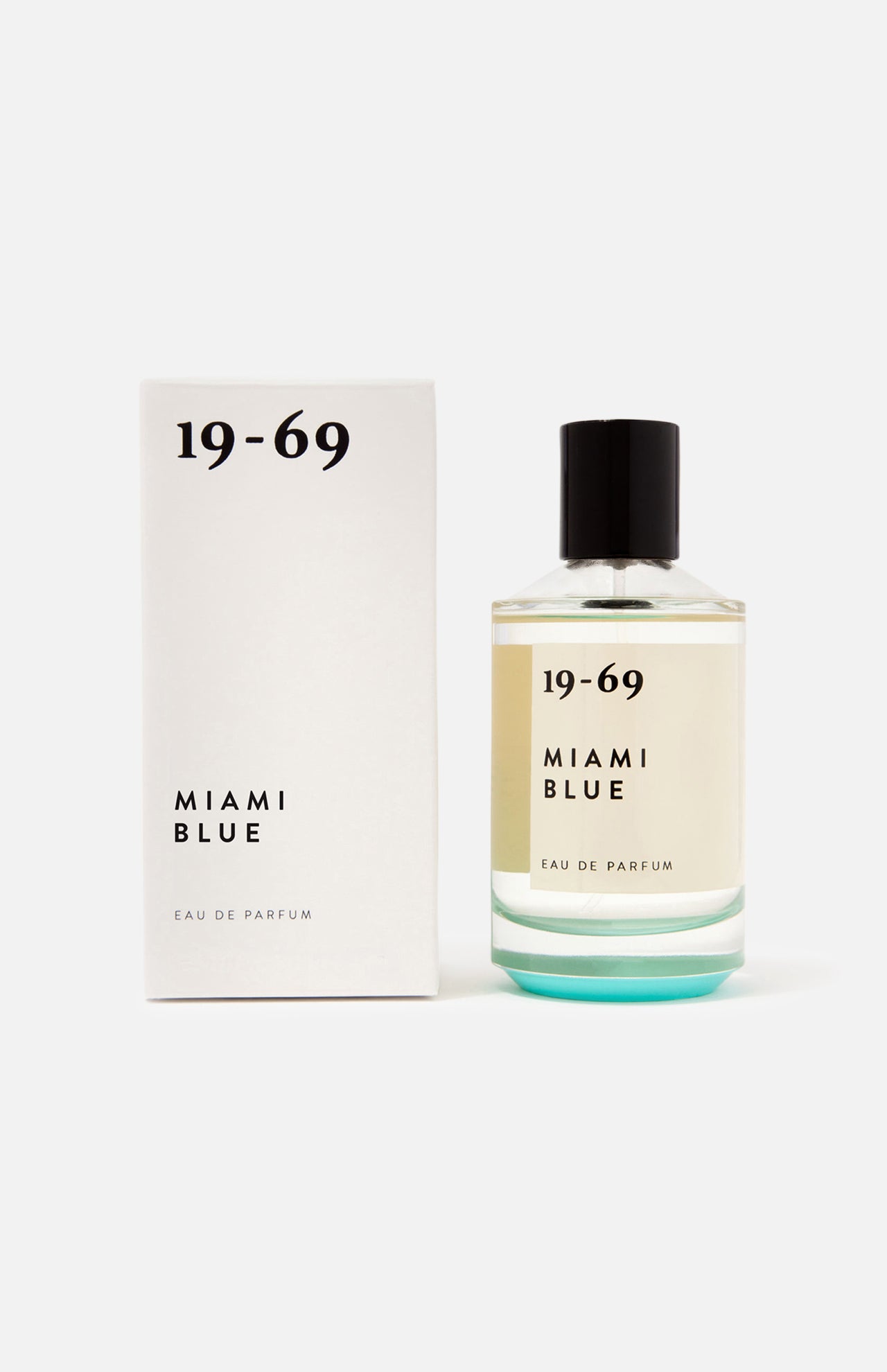 A bottle of 19-69 Miami Blu EDP 100 ml Fragrance stands beside its matching white box with black text on a plain white background. The unisex perfume has a black cap and contains clear liquid inside.