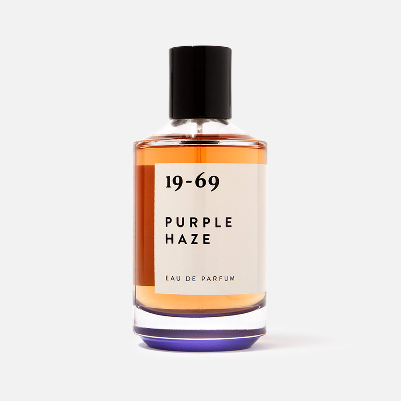 The 19-69 Purple Haze EDP 100 ml Fragrance is a Woodstock-inspired unisex scent in a clear glass bottle with amber liquid, black cap, and minimalist black-on-white label for a unique fragrance experience.