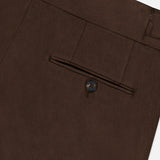 Close-up of the ISAIA Dynamic Comfort Casalnuovo Trouser Pant in dark brown, crafted in Italy, highlighting a back welt pocket with a button and part of the waistband with a belt loop.