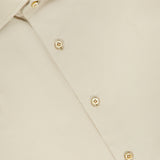 A close-up of the Tessuto Camicia Dress Shirt by ISAIA, featuring a beige fabric, cream-colored buttons, and a distinctive red ISAIA label on the inside collar—an elegant reflection of refined Italian style.