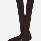 A pair of dark brown Laburnum Long 5x3 Rib Socks by PANTHERELLA, crafted in Merino wool with white branding on the sole, displayed on a plain white background. Made in England for lasting style and comfort.