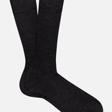 The PANTHERELLA Laburnum Short 5x3 Rib Sock in black Merino wool is shown laid flat on a white background, with one sock overlapping the other.