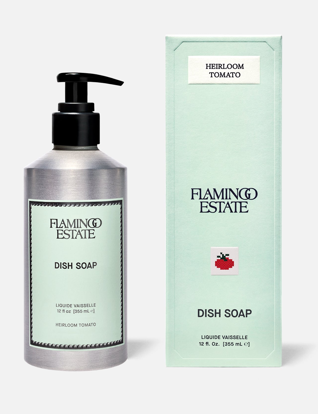 A bottle and box of FLAMINGO ESTATE Heirloom Tomato Dish Soap, both light green with black text. The box features a red tomato graphic, English details, and highlights a fresh tomato leaf scent with biodegradable cleansers.