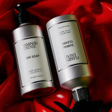 Two silver pump bottles labeled FLAMINGO ESTATE Heirloom Tomato Dish Soap rest on glossy red, crumpled fabric. Minimal labels and black pumps suggest the biodegradable cleanser’s signature tomato leaf scent.