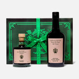 The Tablemates Boxed Oil & Vinegar Gift Set by FLAMINGO ESTATE features two Heritage Olive Oil bottles with light pink labels, presented before a black and green box tied with a green ribbon.