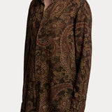 A person wears a RALPH LAUREN COLLECTION Paisley Collared Long Sleeve Blouse, a long-sleeved, button-down dark brown shirt featuring a paisley print.