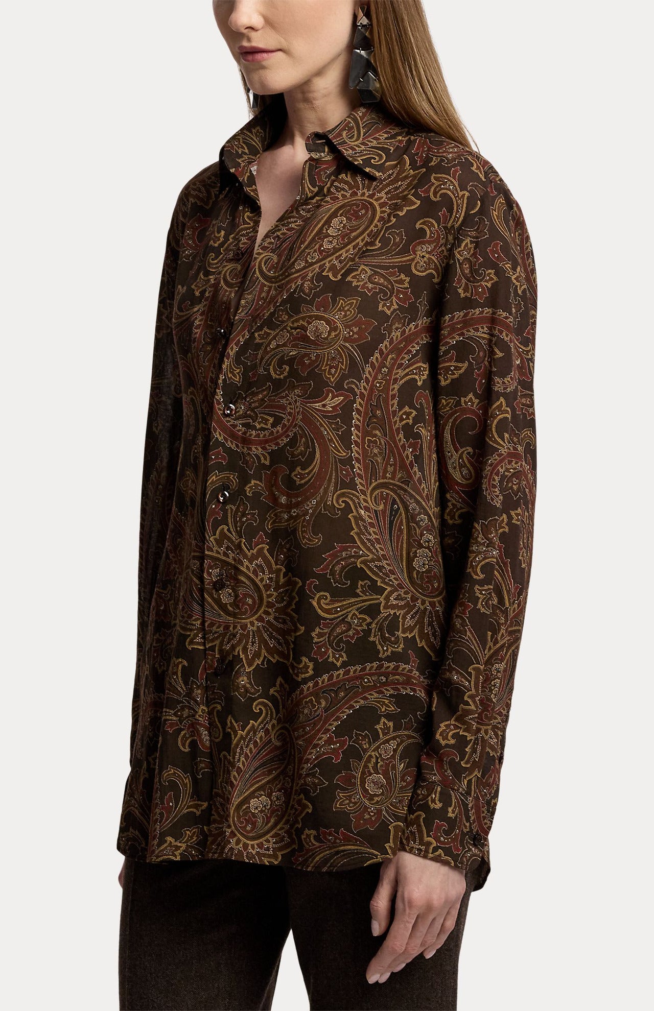 A person wears a RALPH LAUREN COLLECTION Paisley Collared Long Sleeve Blouse, a long-sleeved, button-down dark brown shirt featuring a paisley print.