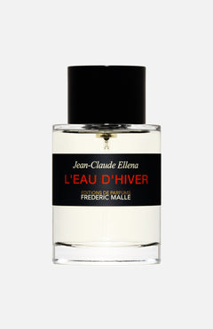 A clear glass bottle with a black cap labeled "L'eau D'Hiver 100 ml Fragrance" by FREDERIC MALLE in white, red, and gold on a black band. This elegant perfume stands out against the light gray background.