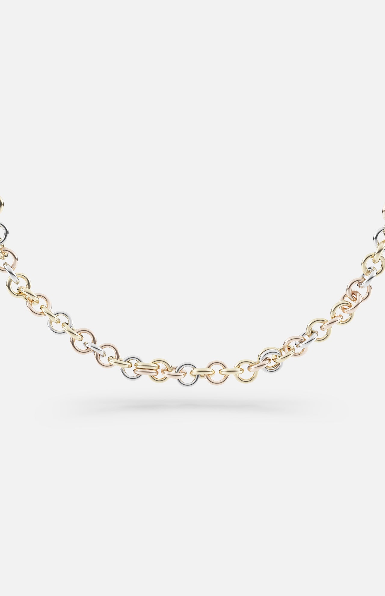 The SPINELLI KILCOLLIN Gravity Chain 20" Necklace showcases interlocking links in yellow, white, and rose gold, highlighting handmade artistry against a plain white background.