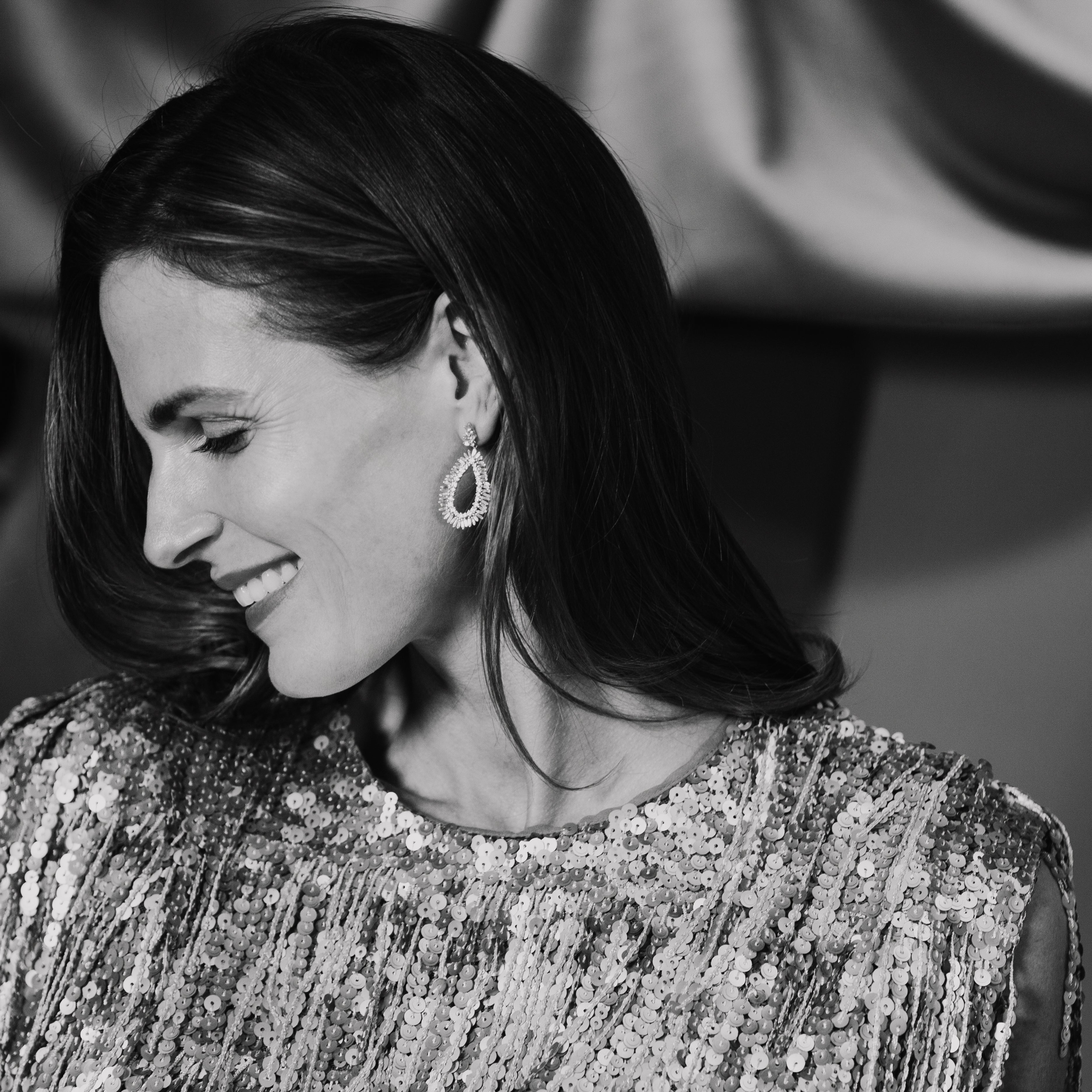 Black and white photo of a woman in a sequined dress holding a bowl.