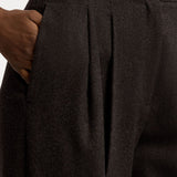 Close-up of dark brown Mini Herringbone Standard Pants in a relaxed fit, featuring front pleats and a side pocket.