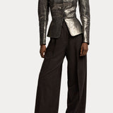A person wearing a metallic silver long-sleeved jacket with a flared waist and RALPH LAUREN COLLECTION Mini Herringbone Standard Pants in dark brown wool flannel with a relaxed fit.