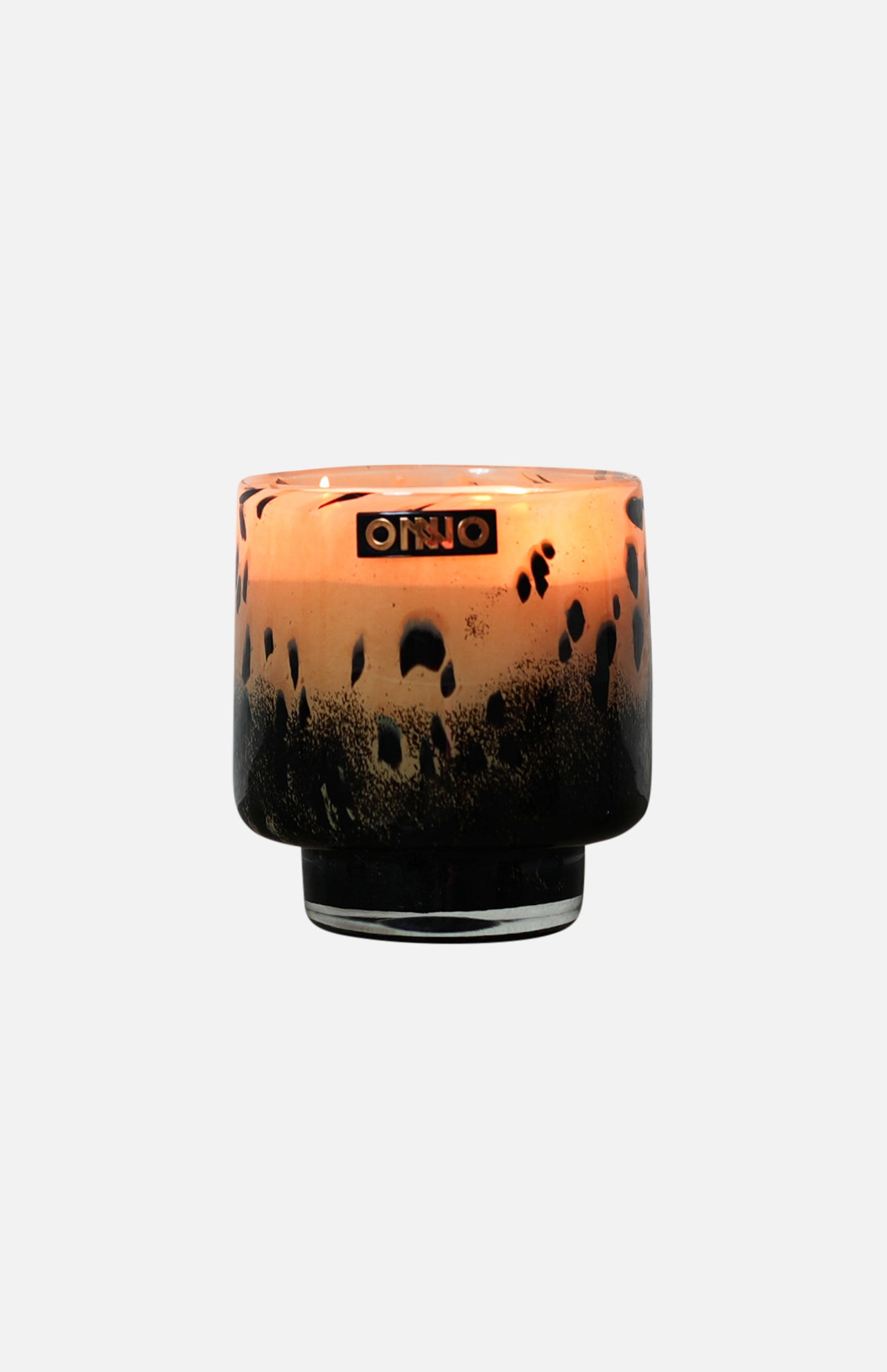 The ONNO Art Brigitte S Zanzibar Candle features a round glass holder with a black and amber leopard print, gold ONNO label, and a luxury hand-poured scented candle inside.