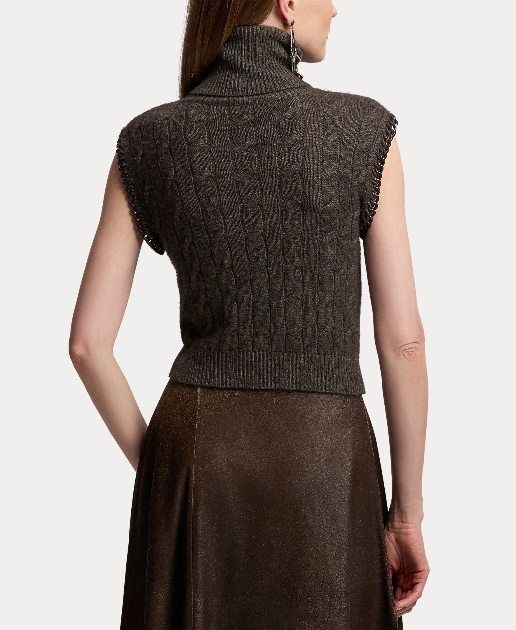 A woman is shown from the back against a plain white background, wearing the RALPH LAUREN COLLECTION Cashmere Turtleneck Sleeveless Sweater in dark gray paired with a brown skirt.