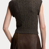 Back view of a person wearing a brown RALPH LAUREN COLLECTION Cashmere Turtleneck Sleeveless Sweater with chain-link trim on the armholes.