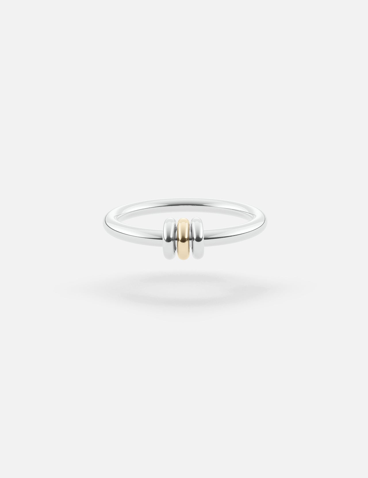 The SPINELLI KILCOLLIN Sirius 3 Annulets Ring is a minimalist unisex sterling silver band featuring two silver beads flanking a gold bead, set against a plain white background—perfect for modular jewelry styling.