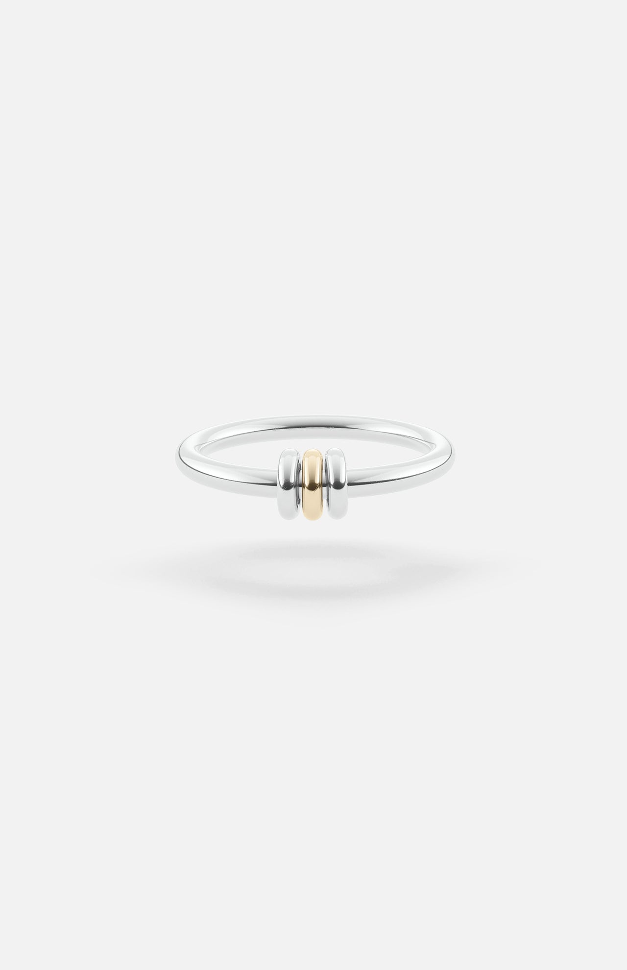 The SPINELLI KILCOLLIN Sirius 3 Annulets Ring is a minimalist unisex sterling silver band featuring two silver beads flanking a gold bead, set against a plain white background—perfect for modular jewelry styling.
