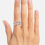A hand with neatly manicured nails displays the SPINELLI KILCOLLIN Sonny Pavé Band Ring—a chunky, linked double-band sterling silver ring—worn on the middle finger against a plain white background.