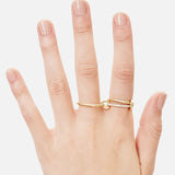 A hand with neatly manicured nails wears the SPINELLI KILCOLLIN Sonny Pavé Band Ring, crafted in yellow gold with a knot design and a row of pavé diamonds, displayed against a plain white background.