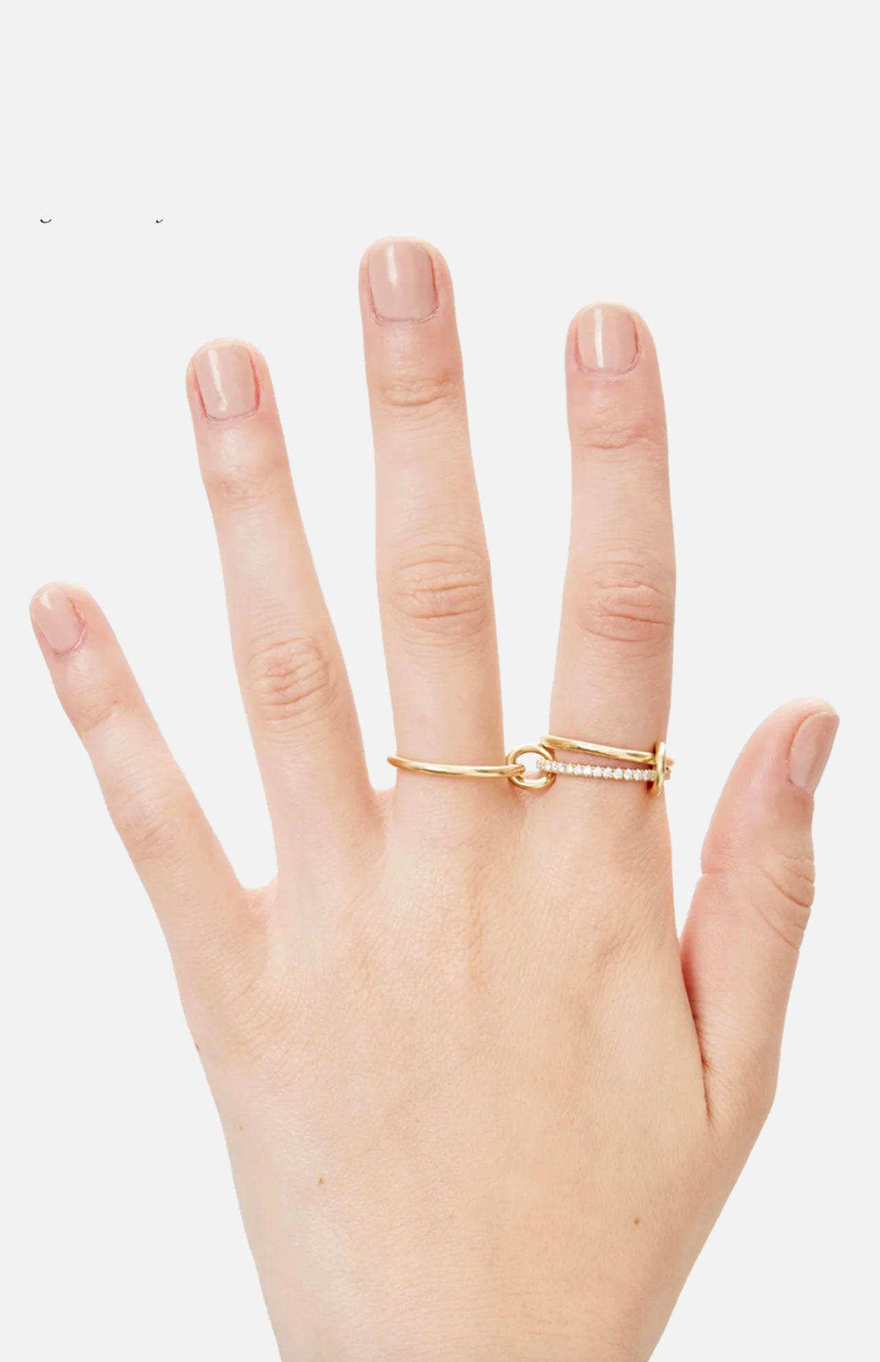 A hand with neatly manicured nails wears the SPINELLI KILCOLLIN Sonny Pavé Band Ring, crafted in yellow gold with a knot design and a row of pavé diamonds, displayed against a plain white background.