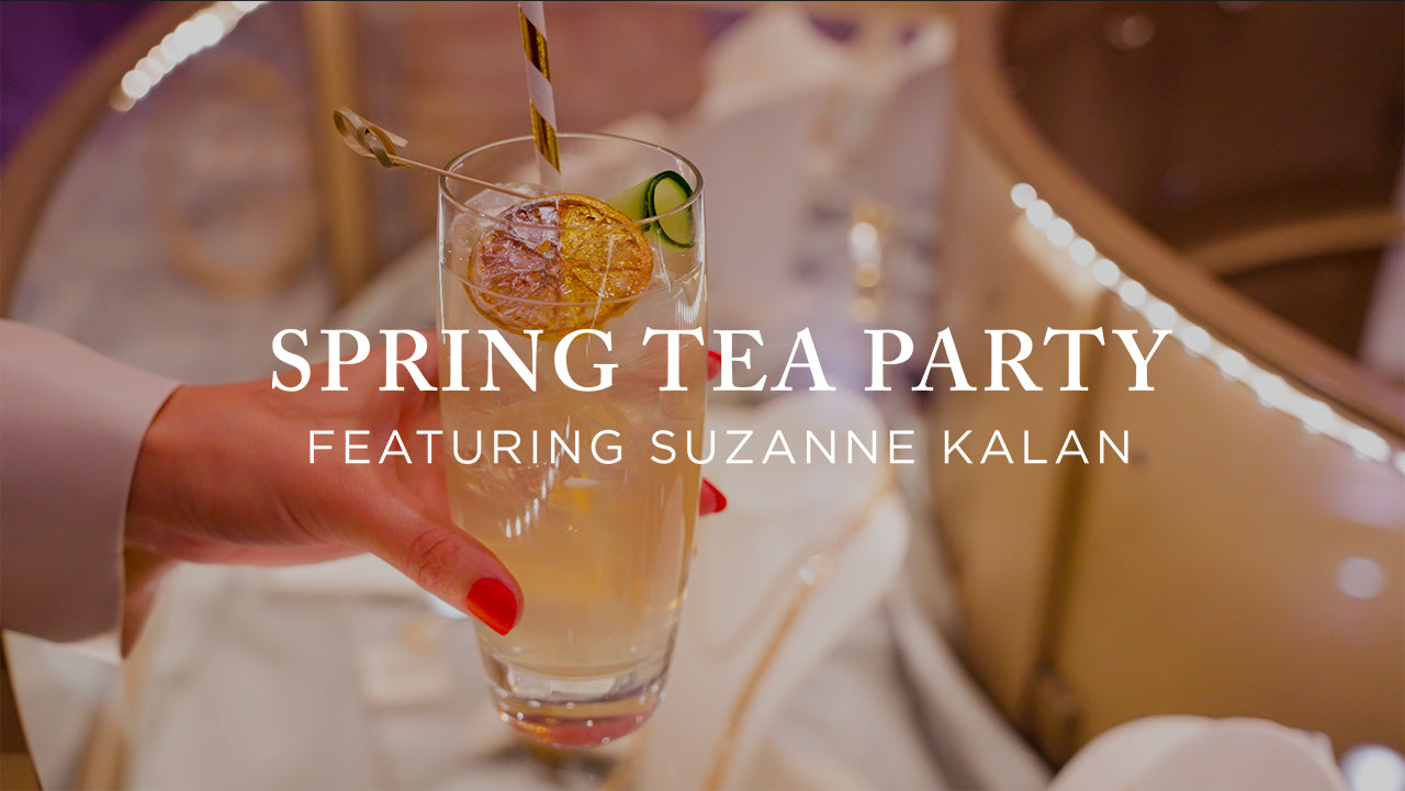 image with text "Spring Tea Party Featuring Suzanne Kalan" image is of a themed glittery cocktail on top of a lit jewelry display case