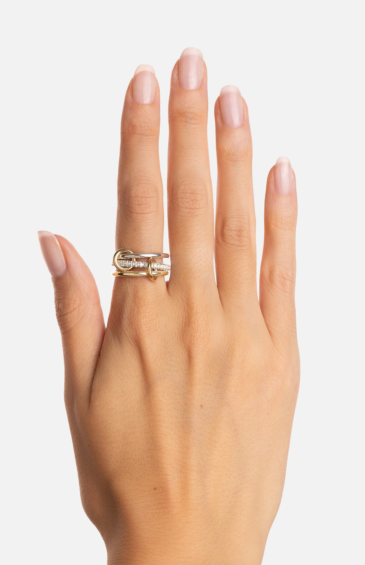 A hand with neatly manicured nails wears the SPINELLI KILCOLLIN Tigris Pavé Band Ring, showcasing its unique modular design on the middle finger against a plain white background.