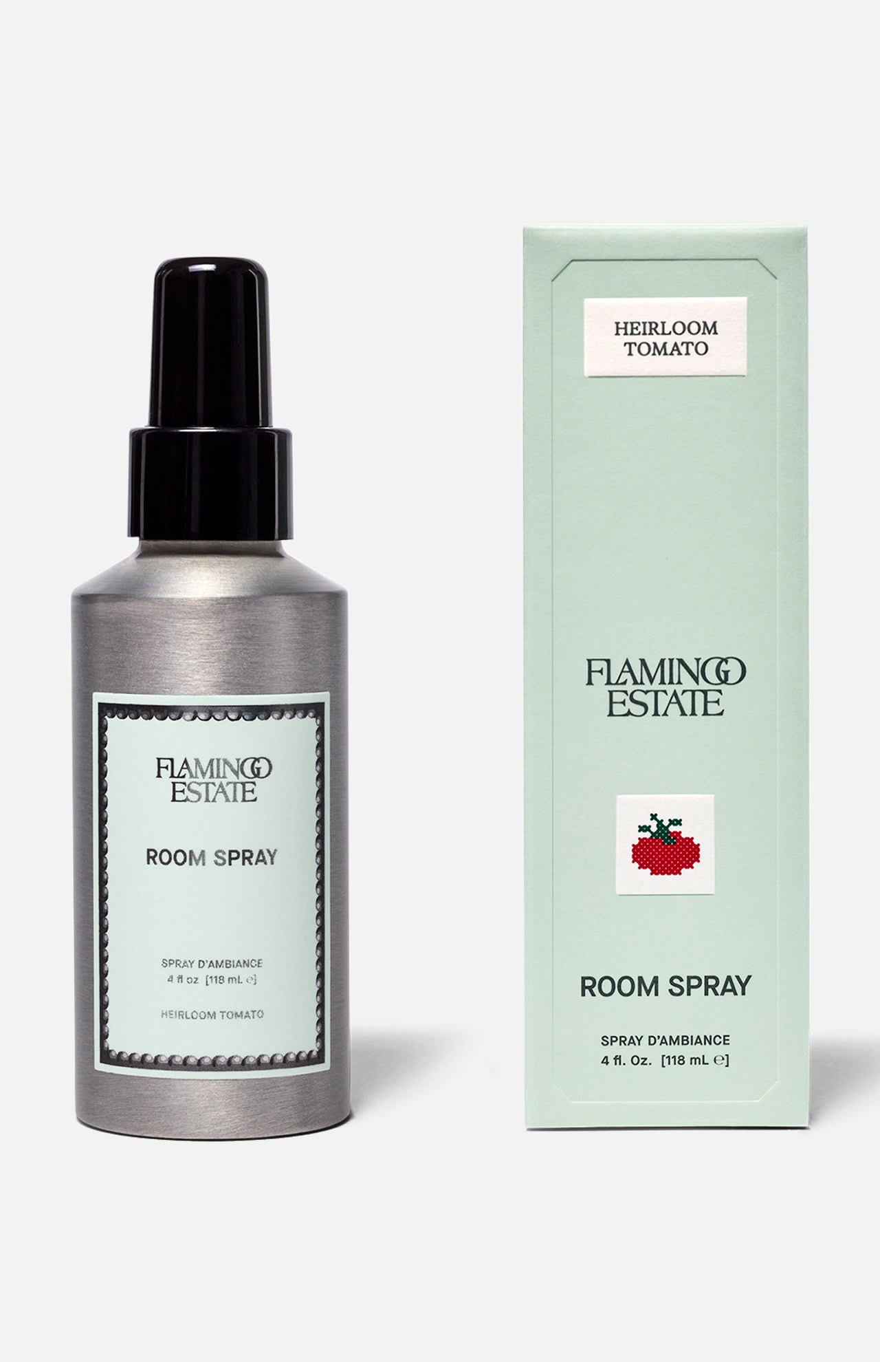 A silver spray bottle and a light green box labeled FLAMINGO ESTATE Roma Heirloom Tomato Room Spray—with the signature tomato illustration—are displayed against a plain background, capturing the fresh, vibrant essence of a summer garden to create an inviting home fragrance experience.