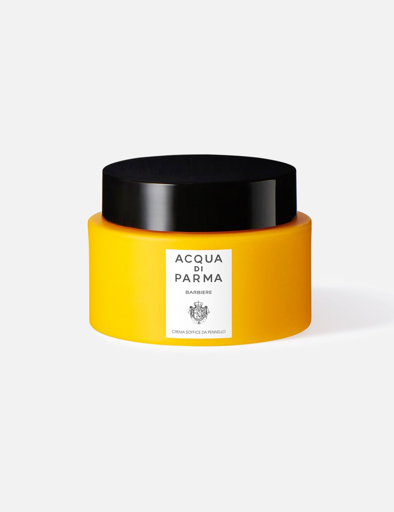 A yellow jar with a black lid labeled ACQUA DI PARMA Barbiere Soft Shaving Cream sits on a white background, featuring the brand’s name and crest, and is formulated to hydrate skin with pomegranate seed oil.
