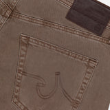 Close-up of the back pocket and waistband of AG Everett Slim Colored Jeans in grey-brown, highlighting decorative pocket stitching and a dark brown leather patch on the waistband.