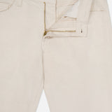 The Everett Pants by AG are light beige slim straight fit jeans, shown with the zipper partially open to reveal the waistband, button, and front pockets against a white background.