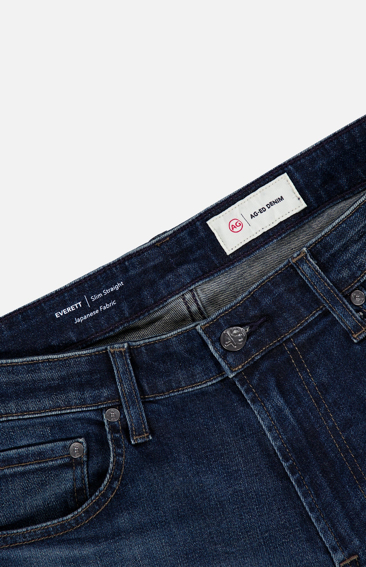 Close-up of AG Everett Jean in 5 Years, showing the dark blue slim fit denim, waistband, buttons, belt loops, pockets, and two labels.