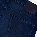 Close-up of the back pocket on AG Everett Jeans in Yountville: ultra-dark blue denim with detailed stitching, a belt loop, and a blank black leather patch on the waistband.